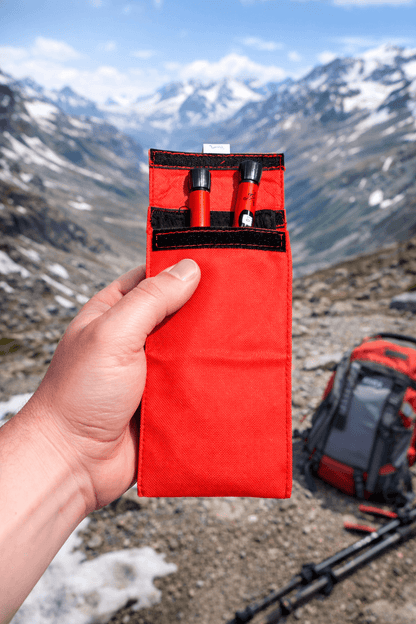Röd kylfodral insulinväska hålls i hand på bergsvandring, designad för att hålla insulin svalt utan batterier eller kylklampar.