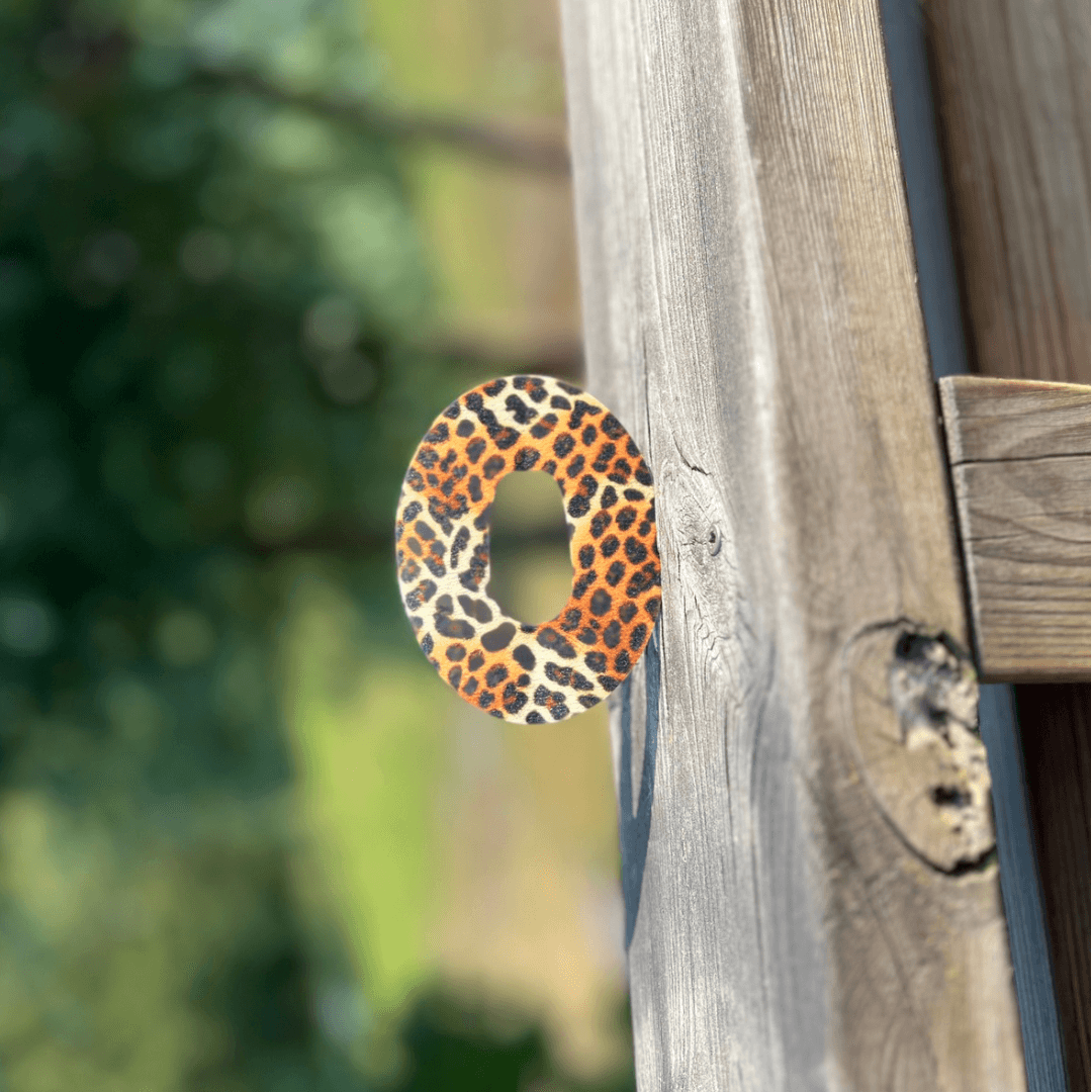 Leopardmönster overpatch för Dexcom G6 sensor på träbakgrund