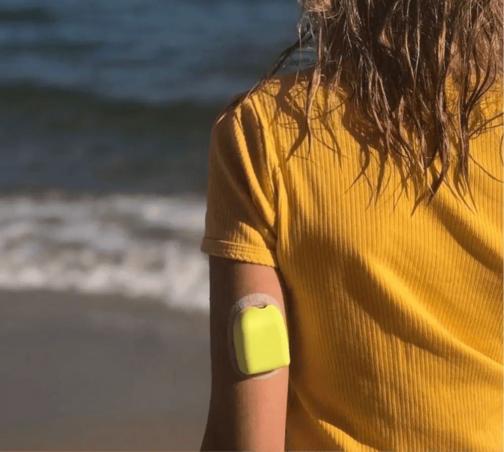 Omnipod Universal PumpCover i bruk på stranden, ger skydd och stil utan att påverka funktionalitet.